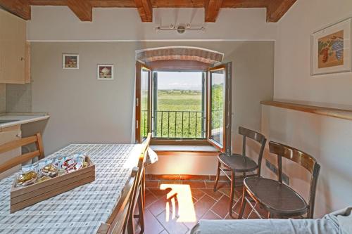 eine Küche mit einem Tisch und Stühlen sowie einem Fenster in der Unterkunft Agriturismo Corte Albarel in Castelnuovo del Garda