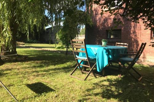Cottage Centulois في Saint-Riquier: طاولة زرقاء وكراسي تجلس على العشب