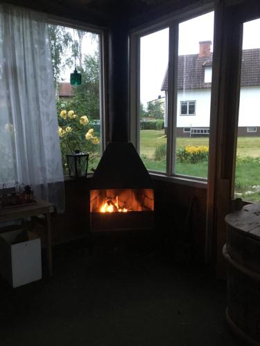 a fireplace in a living room with a window at Arthome Småland in Ruda