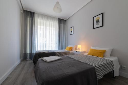 a hotel room with two beds and a window at Apartamento el centro in Logroño