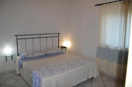 um quarto com uma cama grande num quarto em La Maddalena Apartment em La Maddalena