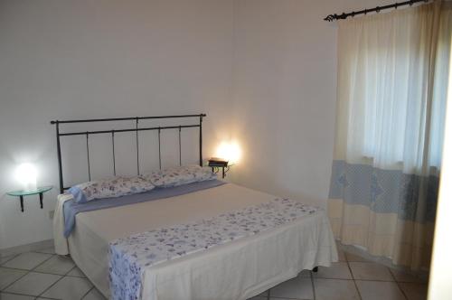a bedroom with a large bed in a room at La Maddalena Apartment in La Maddalena