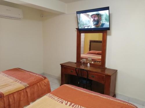 - une télévision installée au-dessus d'une commode dans une chambre dans l'établissement HOTEL BAEZA, à Delicias