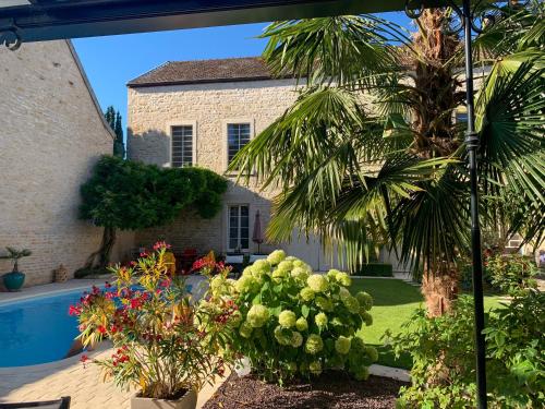 ムルソーにある"LE JARDIN" Chambre de charme, piscine à Meursaultの庭園とスイミングプール付きの家