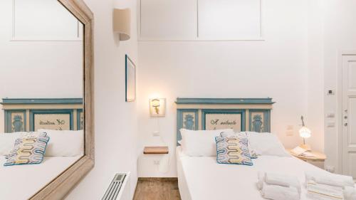 a hotel room with two beds and two lamps at Addimora Boutique Suites in Palermo