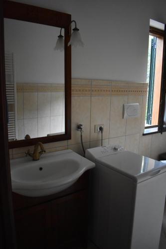 y baño con lavabo, espejo y aseo. en Villa Di Martino, en Vico Equense