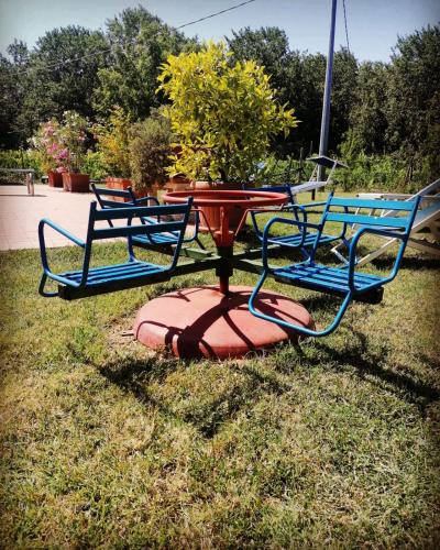 a table with three chairs sitting on the grass at Little Star Pioppa in Riondi