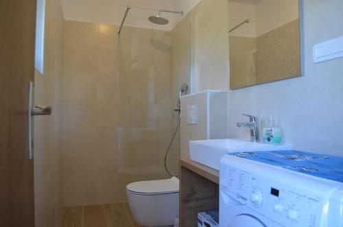 uma casa de banho com um chuveiro, um WC e um lavatório. em Apartments Mare em Malinska