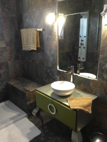 La salle de bains est pourvue d'un lavabo et d'un miroir. dans l'établissement Chambre d Hôte exclusif Naturiste et Nudiste CASA AMSYL adultes only, à Paderne