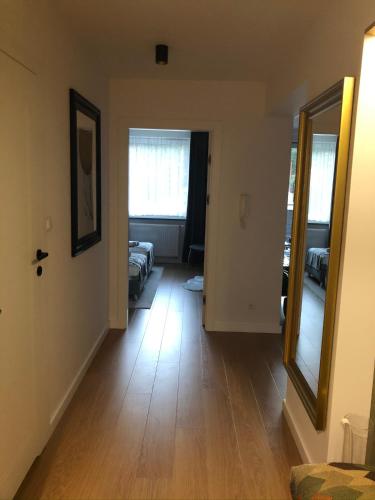 a hallway with a mirror and a room with two beds at apartament LeśnaCedzyna in Cedzyna