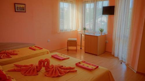una habitación con 2 camas y una mesa con toallas en Tatyana Guest House, en Byala
