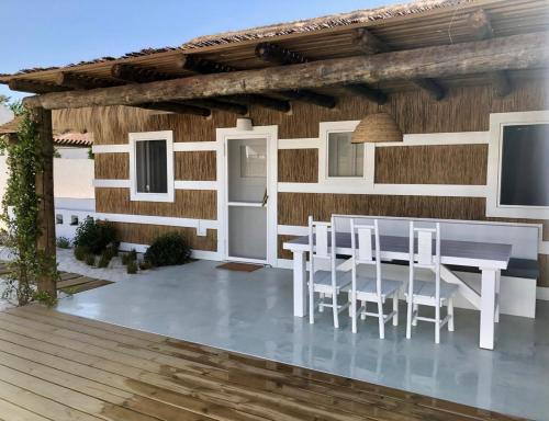 una casa con una mesa blanca y sillas en una terraza en Cabana 2 da Comporta, en Comporta