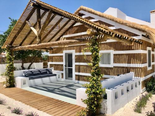 a house with a wooden deck with a pergola at Cabana 2 da Comporta in Comporta
