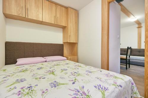 a bedroom with a bed with a floral bedspread at Mobile homes village "MUNGOS" Mljet in Babino Polje
