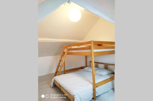 ein Schlafzimmer mit Etagenbetten im Dachgeschoss in der Unterkunft Maison Montfermeilloise entre Paris et Disneyland in Montfermeil
