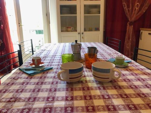 a table with two cups and saucers on it at Appartamento Balconcino su Lazise in Lazise