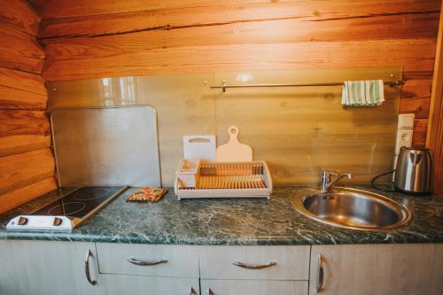 a kitchen with a sink and a counter top at Guest House Baltās Dūjas in Saulkrasti