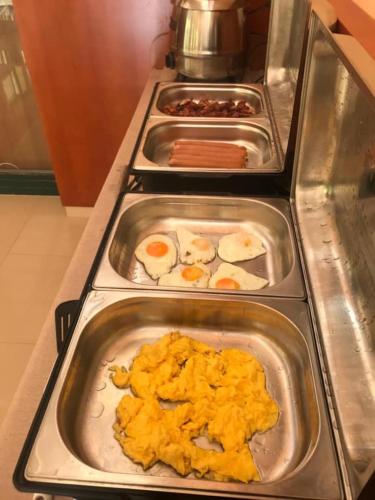 a row of trays of food on a buffet at Rábensteiner Panzió in Fertőd
