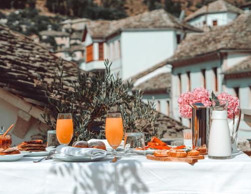 una mesa con comida, zumo de naranja y bebidas en Hotel Argjiro, en Gjirokastra