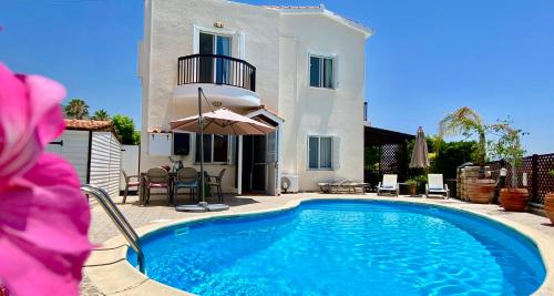 una piscina frente a una casa en VILLA ALICIA with priv pool, beautiful garden and shady veranda- 5 min to the beach, en Peyia
