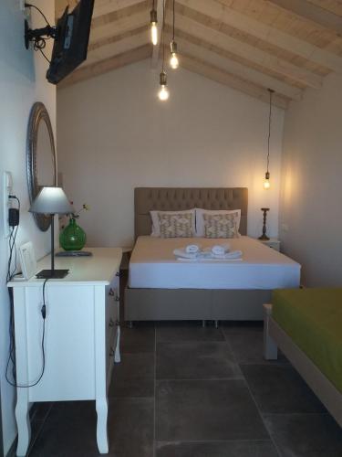 a bedroom with a bed and a desk with a lamp at Sunrise Studio in Skala Kallirachis