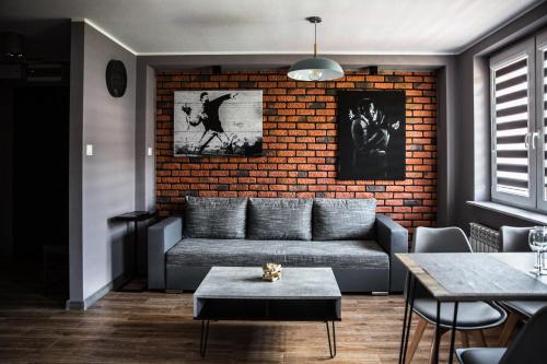a living room with a couch and a brick wall at Apartament Chillout in Ustrzyki Dolne