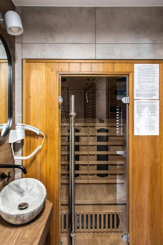 a bathroom with a glass shower with a sink at Apartament Chillout in Ustrzyki Dolne