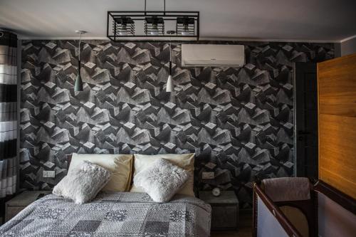 a bedroom with a bed and a wall covered in triangles at Apartament Chillout in Ustrzyki Dolne