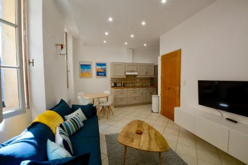 a living room with a blue couch and a table at Old Town Antibes Apartment in Antibes