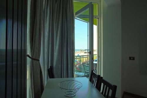 ein Tisch mit einer Glasschüssel neben einem Fenster in der Unterkunft Isabelle Apartament Alezzi Beach Resort Mamaia Nord in Mamaia Nord – Năvodari