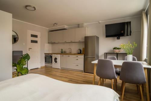 a kitchen and living room with a table and chairs at APARTAMENTY CENTRUM in Braniewo