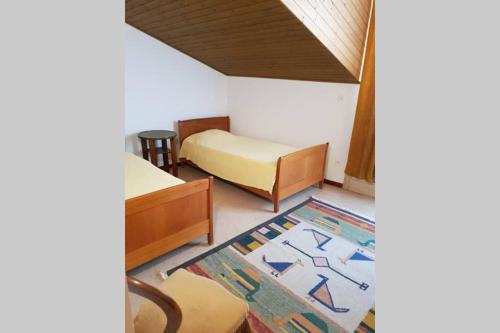 Kleines Zimmer mit 2 Betten und einem Teppich in der Unterkunft Bezauberndes Haus für erholsame Ferien im Puschlav in Campascio