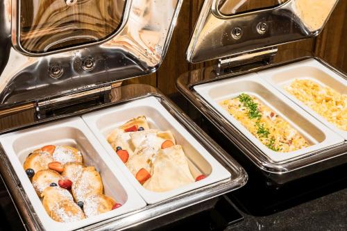 three trays of food in trays in an oven at Hotel Wersal in Zakopane