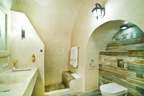łazienka z toaletą i kamienną ścianą w obiekcie ANTELMI LUXURY VILLA w Firze