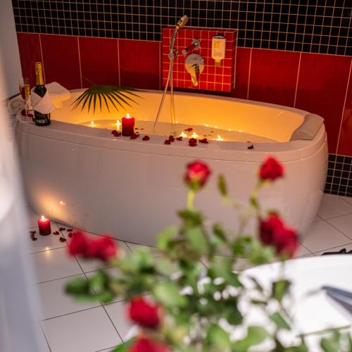 a bathroom with a bath tub with candles and roses at Hotel Bardo in Bardo