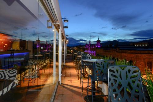 a restaurant patio with tables and chairs at night at Hotel Los Juaninos in Morelia