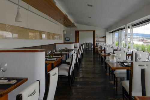 a dining room with wooden tables and white chairs at Hotel Los Juaninos in Morelia