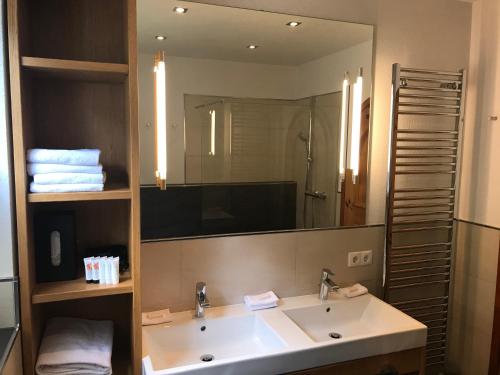 Un baño con lavabo y un espejo grande. en Das Anja Sunleit`n, en Filzmoos