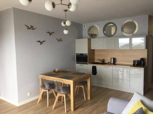 a kitchen with a table and chairs in a room at Apartament Słoneczny przy plaży in Dziwnówek