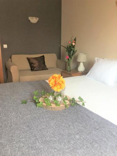 a flower arrangement on a bed in a hotel room at O Pátio in Fernao Ferro