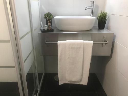 a bathroom with a sink and a white towel at O Pátio in Fernao Ferro