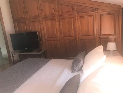 a bedroom with a large bed with a television at O Pátio in Fernao Ferro