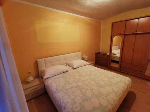 a bedroom with a bed and a dresser and a mirror at Apartment Oblak in Vrsi