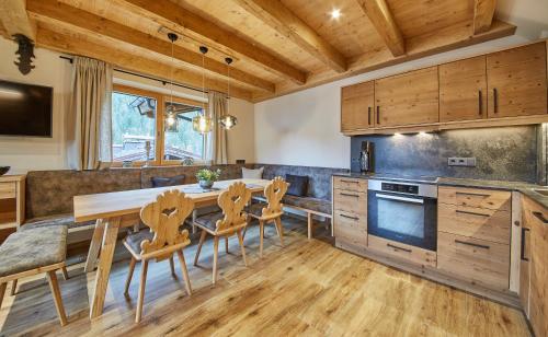 a kitchen with wooden cabinets and a table and chairs at Chalet Dirndl und Buam in Saalbach-Hinterglemm
