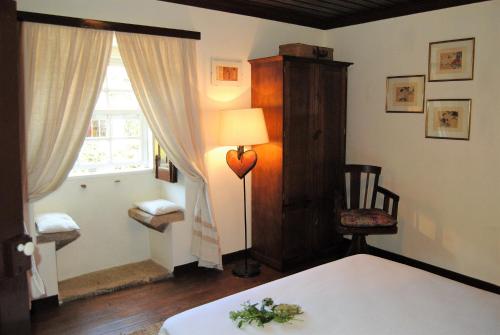 a bedroom with a bed and a lamp and a window at Casa de Cerqueda in Celorico de Basto
