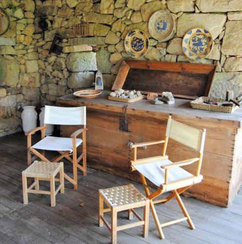 two chairs and a counter with a stone wall at Casa de Cerqueda in Celorico de Basto
