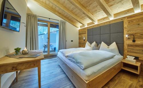 a bedroom with a large bed and a desk at Chalet Dirndl und Buam in Saalbach-Hinterglemm