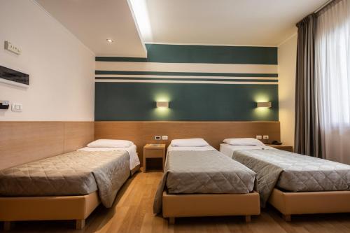 a hospital room with two beds and a green wall at Hotel Centro Benessere Gardel in Arta Terme