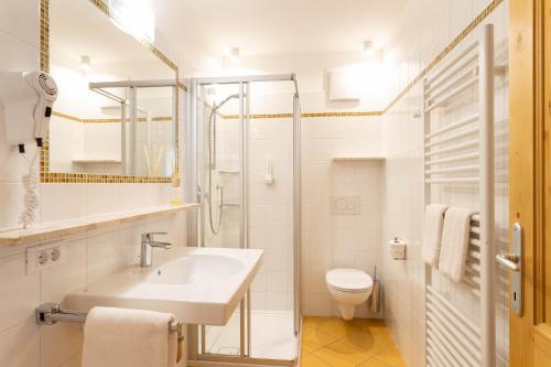 biała łazienka z umywalką i toaletą w obiekcie Kreuzwegerhof Nals w mieście Nals