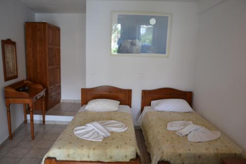 two beds in a room with towels on them at Studio Ioanna Tinos in Kionia